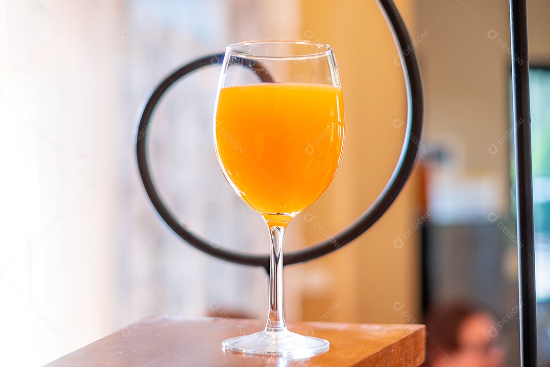 Suco de laranja em uma taça de vinho é colocado sobre a mesa da cozinha.