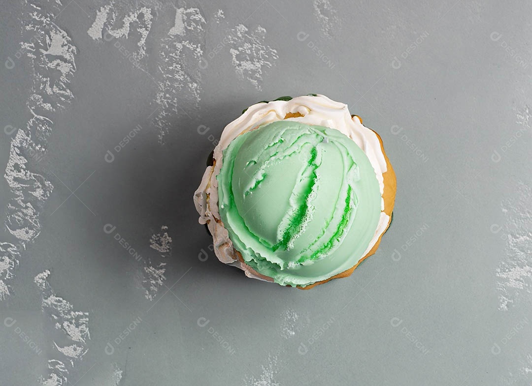 Cupcake com cobertura verde e branca sob fundo isolado