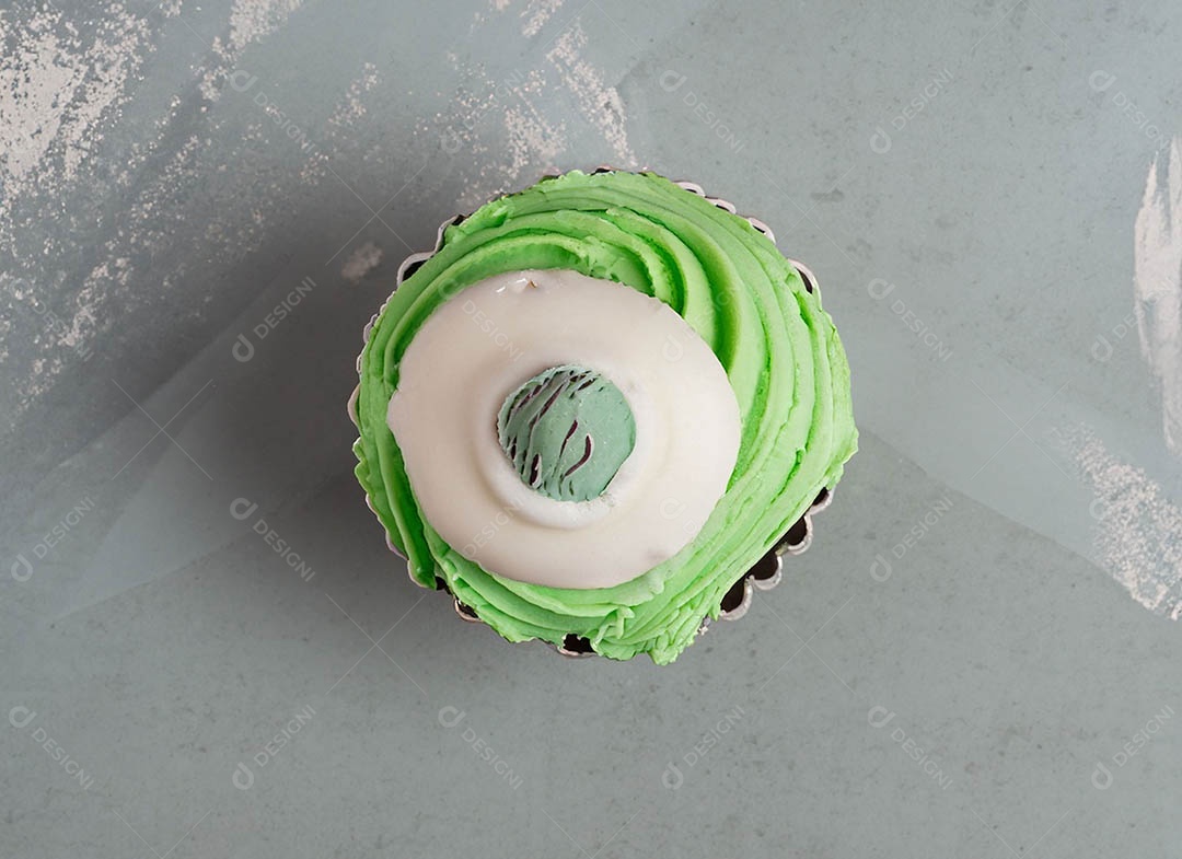 Cupcake com cobertura verde e branca sob fundo isolado