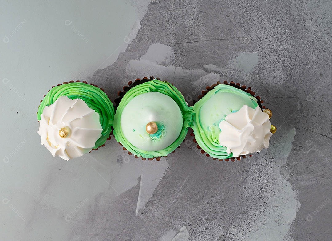 Cupcake com cobertura verde e branca sob fundo isolado