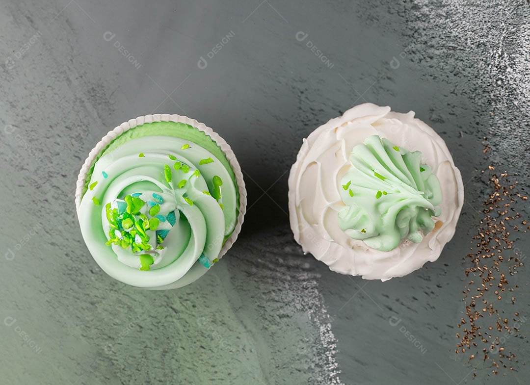 Cupcake com cobertura verde e branca sob fundo isolado