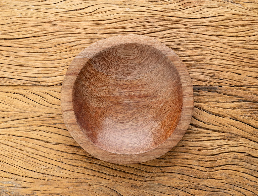 Tigela de madeira artesanal vazia sobre a mesa de madeira