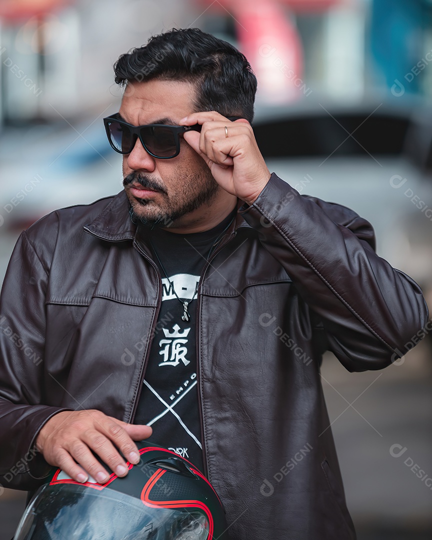 Homem lindo de meia idade usando óculos de sol e segurando uma capacete