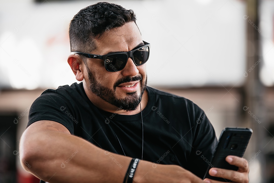 Homem de meia idade bonito posando para foto com celular na mão