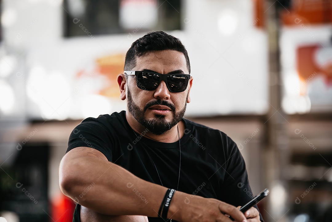 Homem de meia idade bonito posando para foto com celular na mão