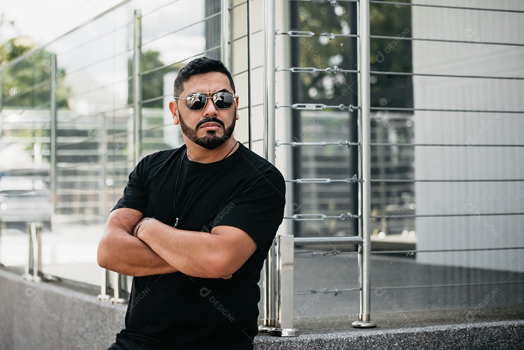 Homem bonito de meia idade serio de braços cruzados