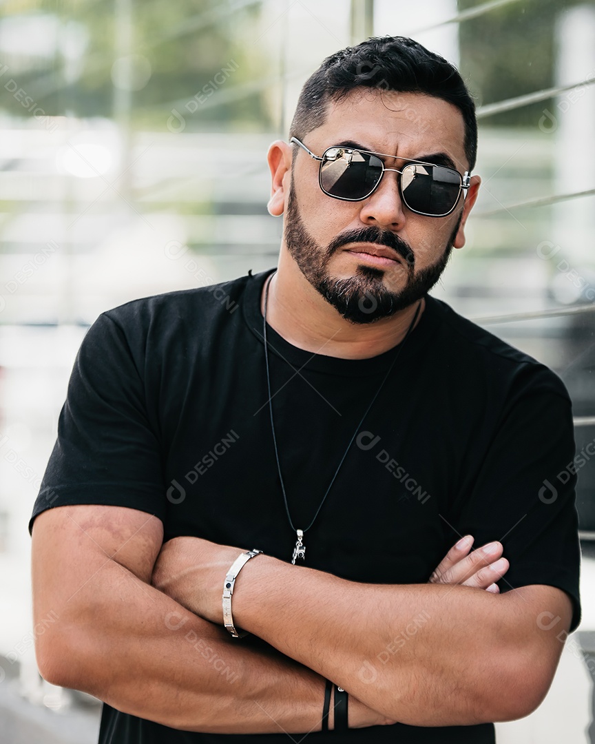 Homem bonito de meia idade serio de braços cruzados