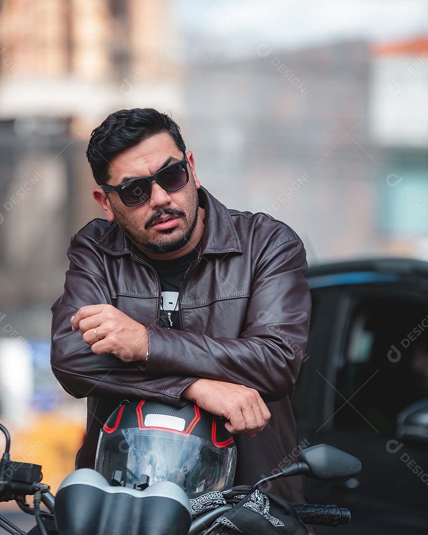 Homem bonito serio em cima de uma moto posando