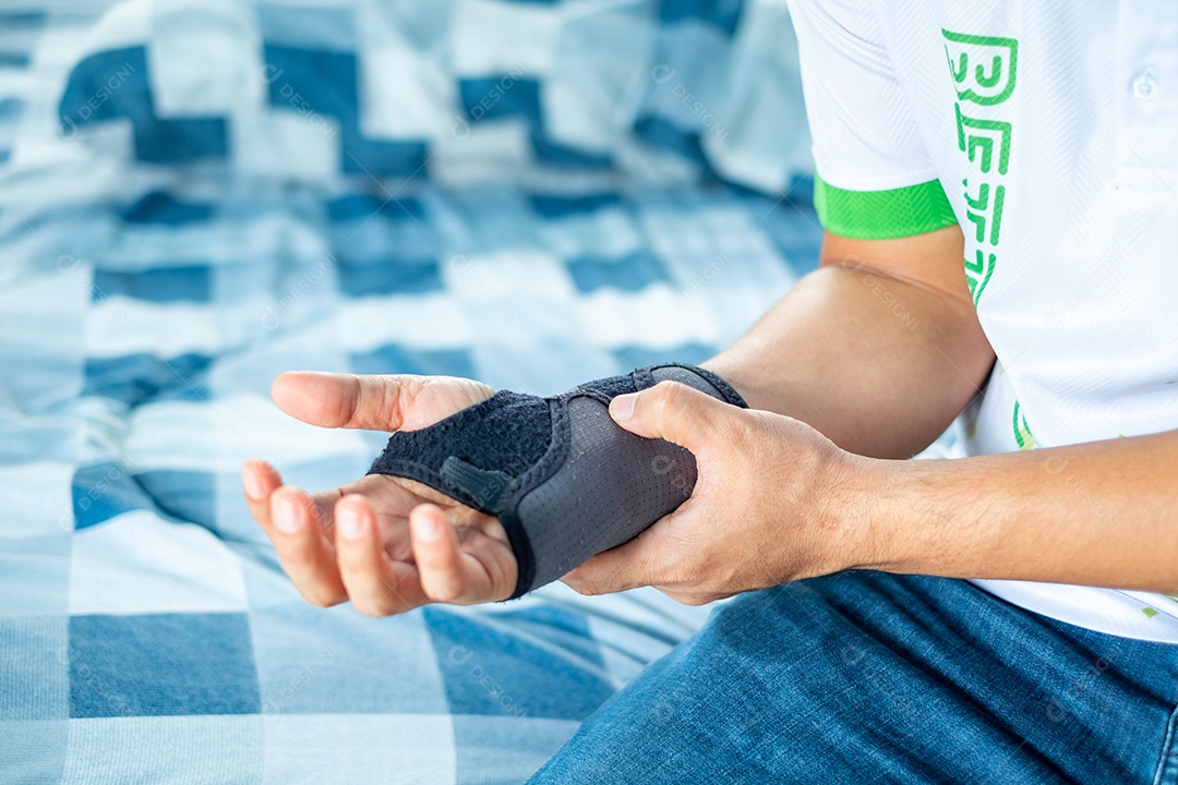 Homem segurando o pulso com tala macia devido a lesão no pulso em casa