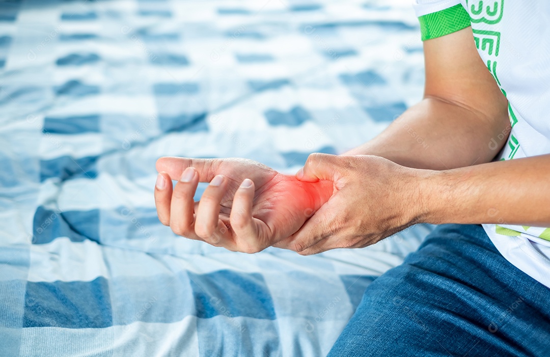 Homem segurando o pulso devido a lesão no pulso em casa