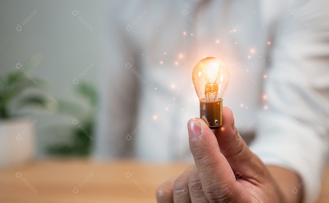 Humano está segurando uma lâmpada. Representa o conceito de educação, aprendizado, inovação e sucesso.