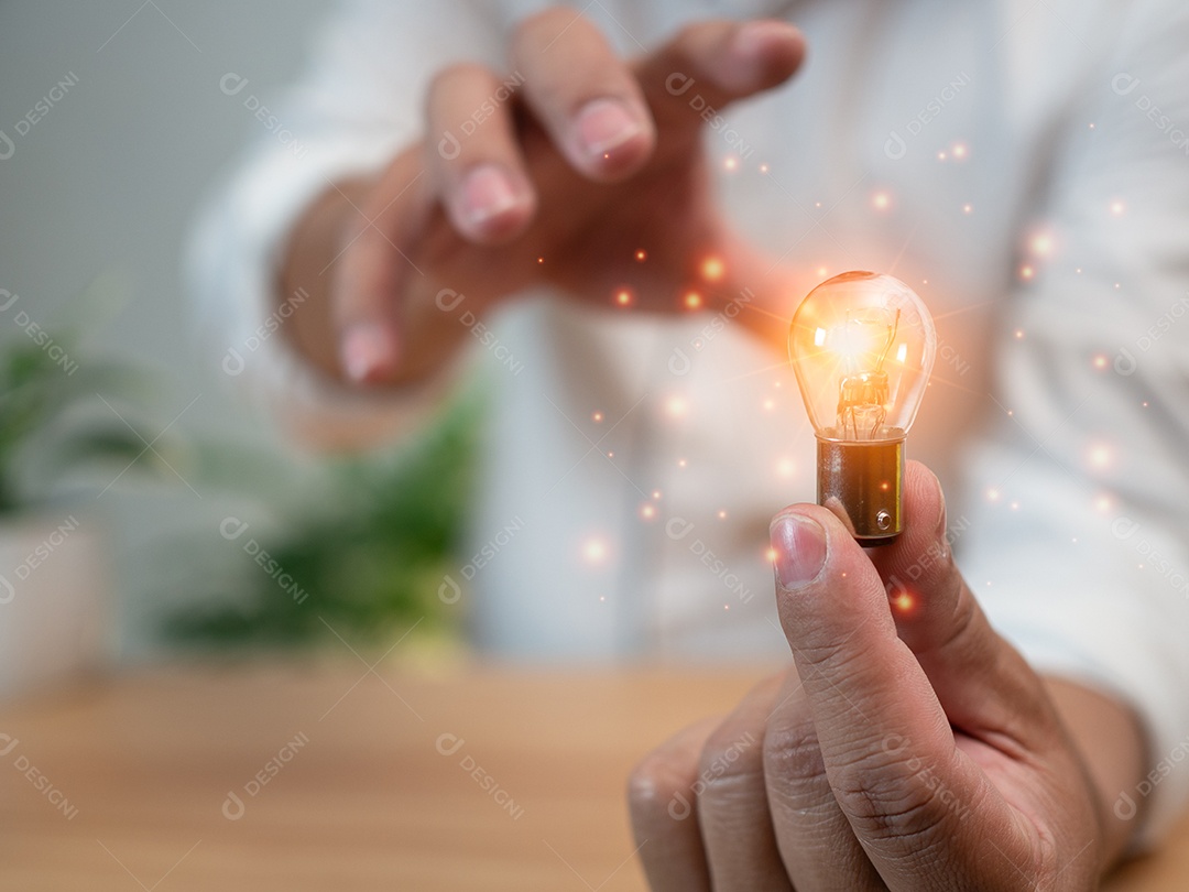 Humano está segurando uma lâmpada. Representa o conceito de educação, aprendizado, inovação e sucesso.