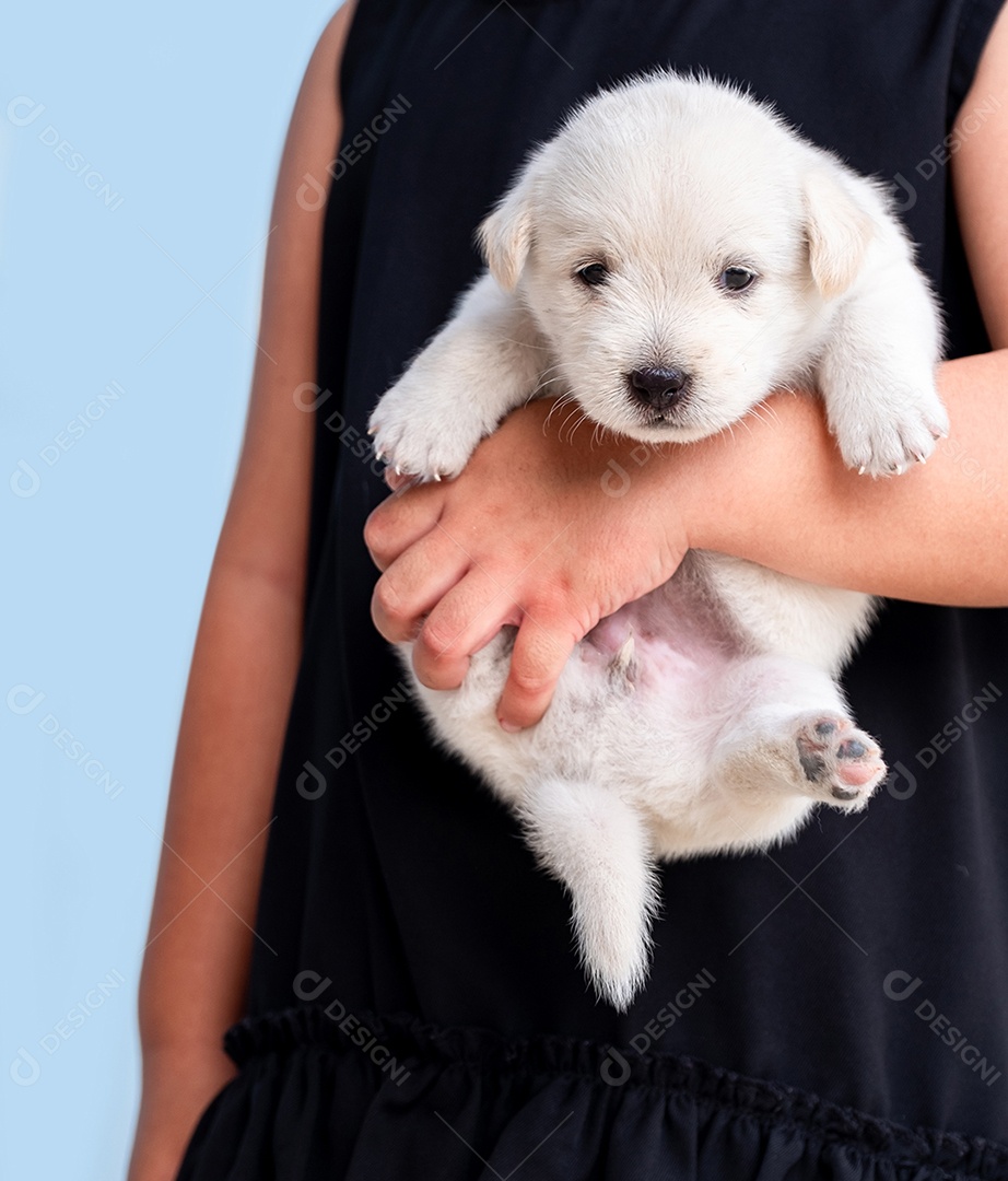 Menina de camisa preta segurando um cachorrinho marrom