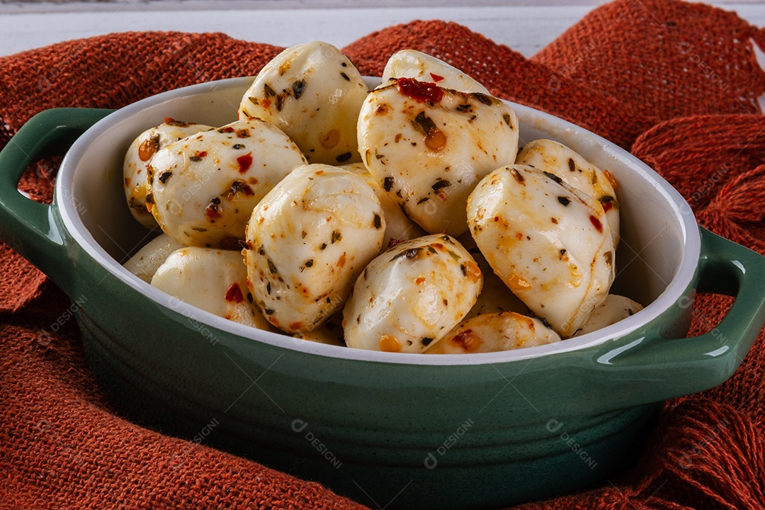 Recipiente de porcelana com bolinhas de mussarela de búfala temperada.