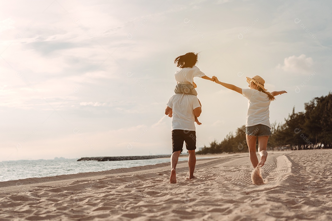 A família asiática feliz aprecia a praia do mar. pai, mãe e filha se divertindo brincando