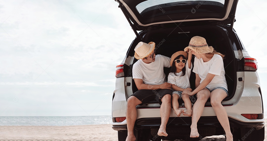 A família asiática feliz aprecia a praia do mar. pai, mãe e filha se divertindo brincando