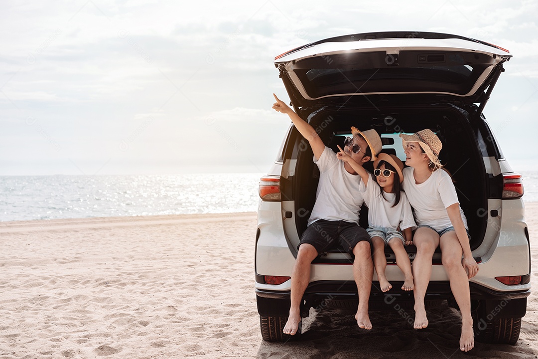 A família asiática feliz aprecia a praia do mar. pai, mãe e filha se divertindo brincando