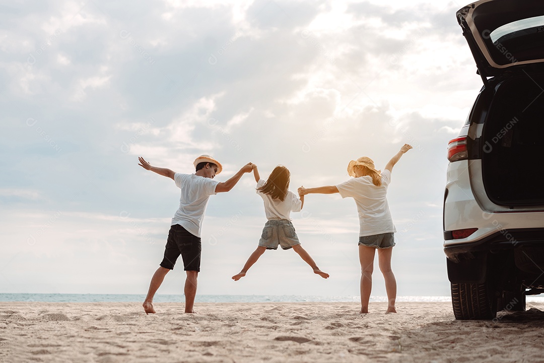 A família asiática feliz aprecia a praia do mar. pai, mãe e filha se divertindo brincando