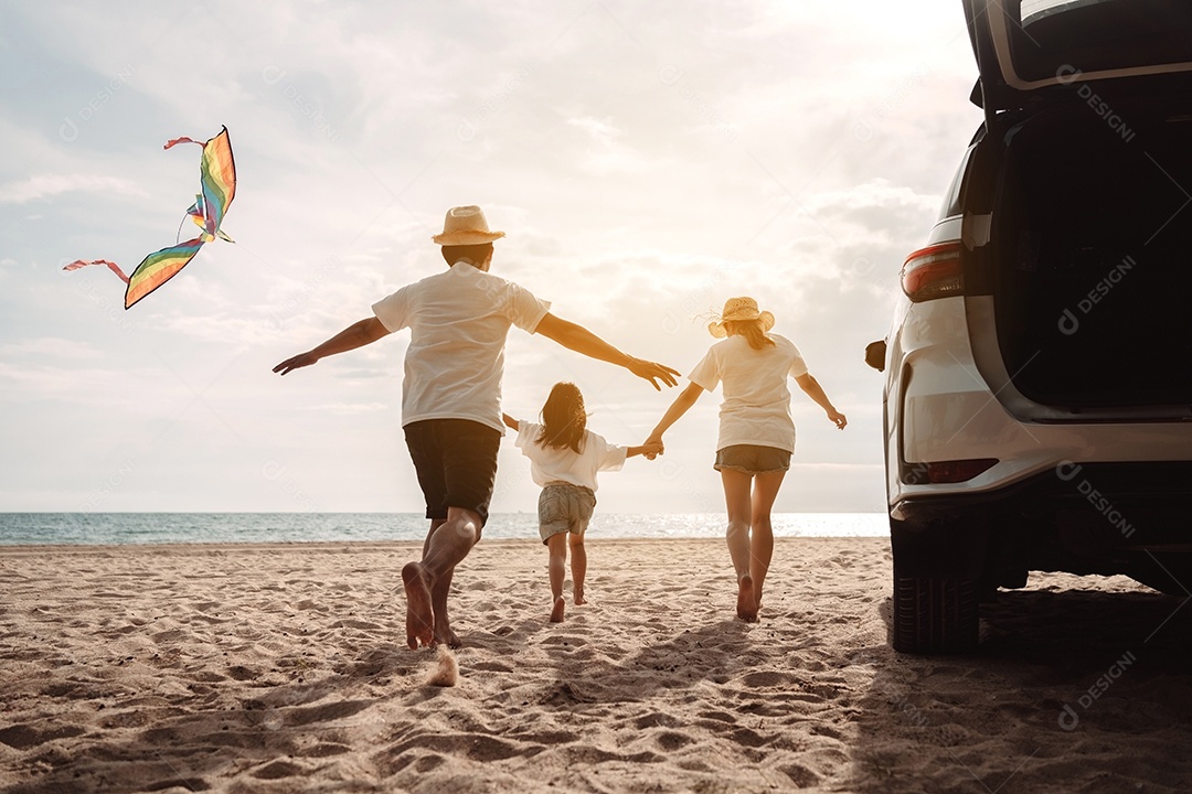 A família asiática feliz aprecia a praia do mar. pai, mãe e filha se divertindo brincando
