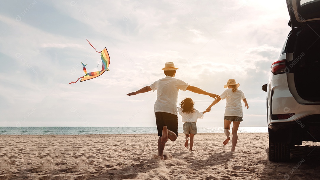 A família asiática feliz aprecia a praia do mar. pai, mãe e filha se divertindo brincando