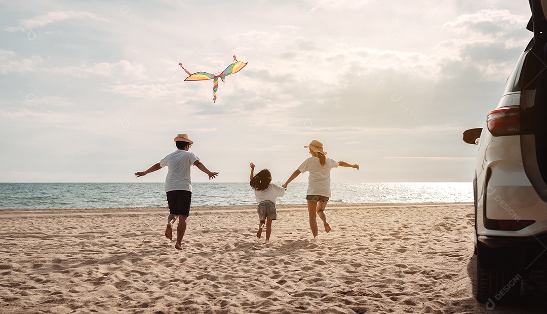 A família asiática feliz aprecia a praia do mar. pai, mãe e filha se divertindo brincando