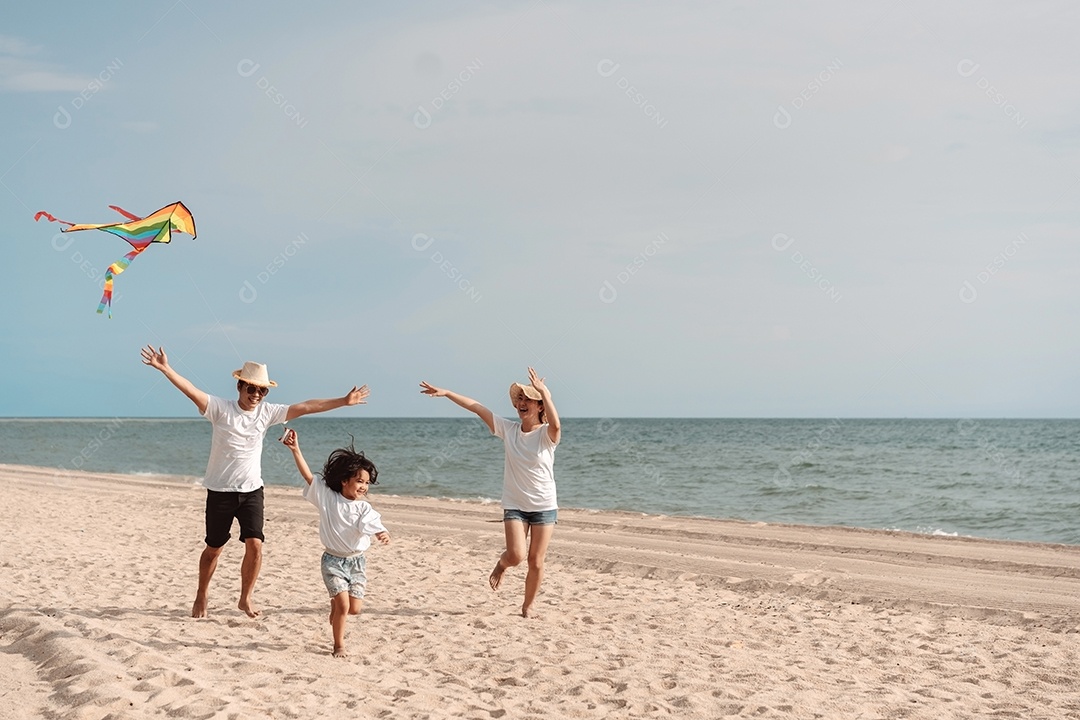 A família asiática feliz aprecia a praia do mar. pai, mãe e filha se divertindo brincando