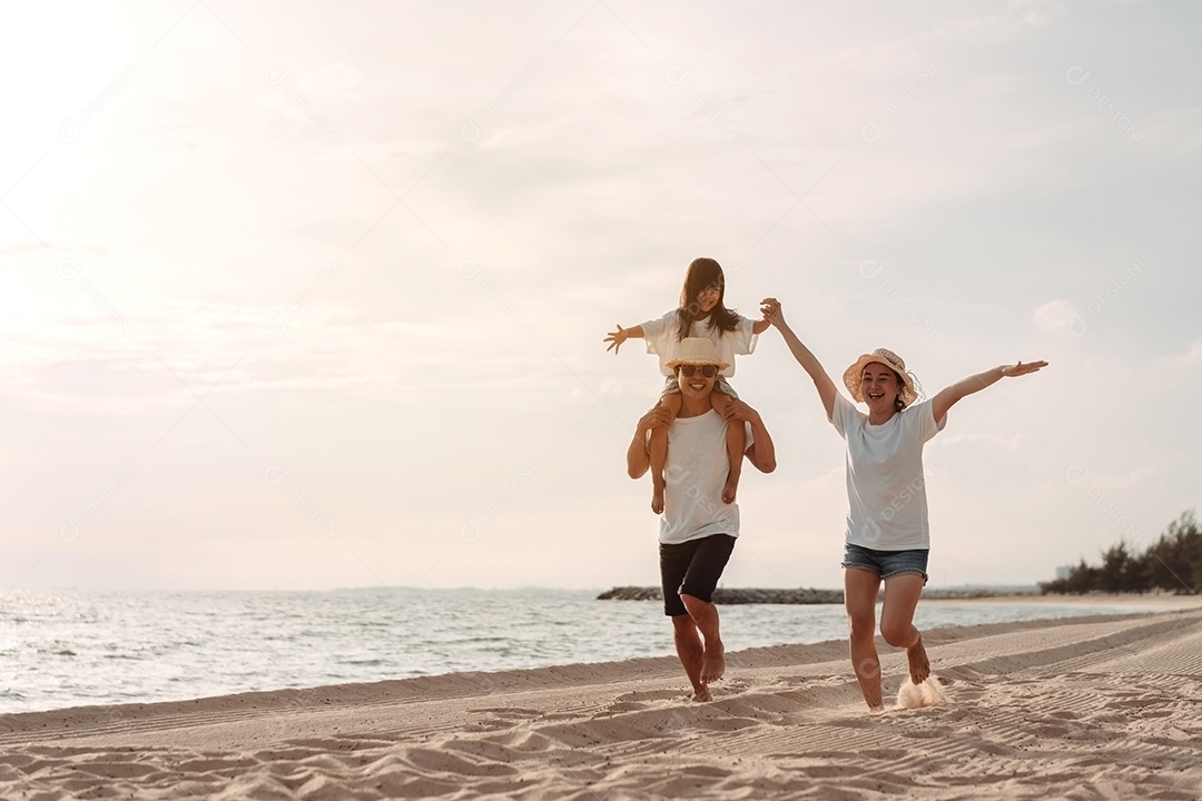 A família asiática feliz aprecia a praia do mar. pai, mãe e filha se divertindo brincando