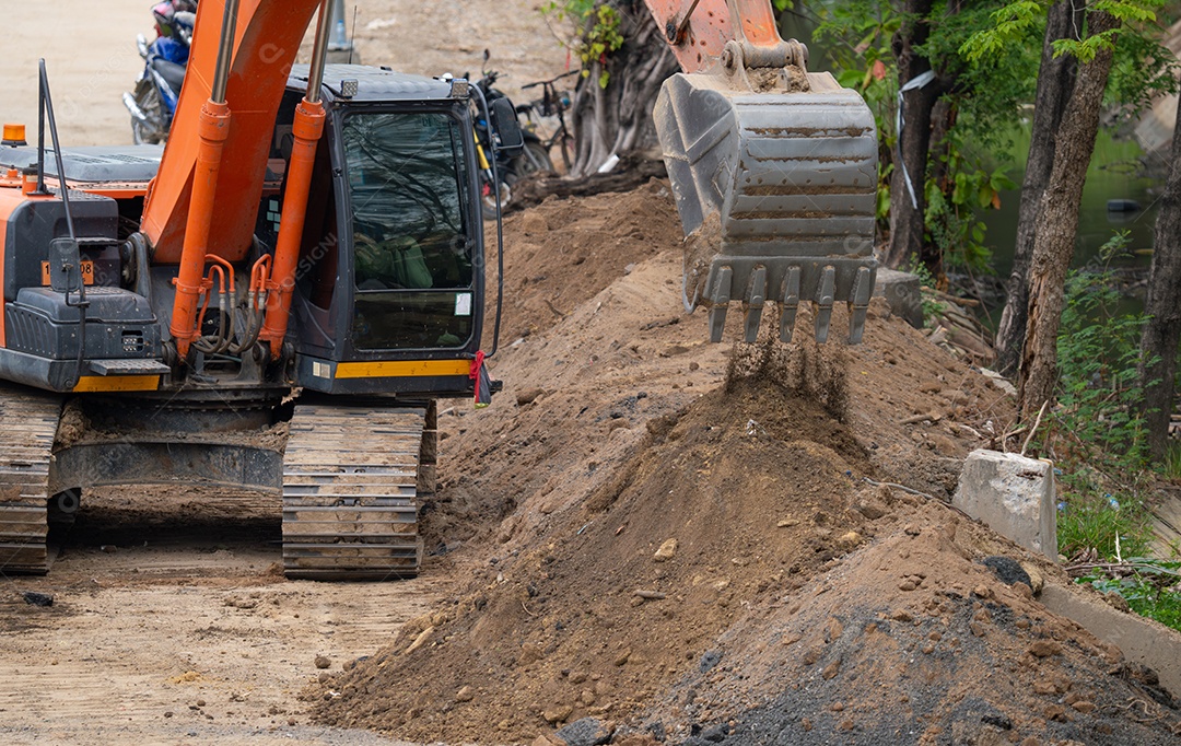 Escavadeira trabalhando cavando solo em canteiro de obras