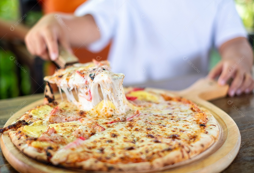 Mão de criança segurando fatia de pizza