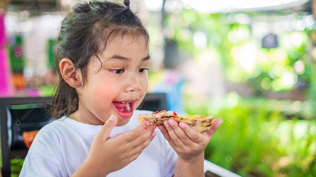 Menina asiática vestindo uma camisa branca e segurando uma fatia de pizza