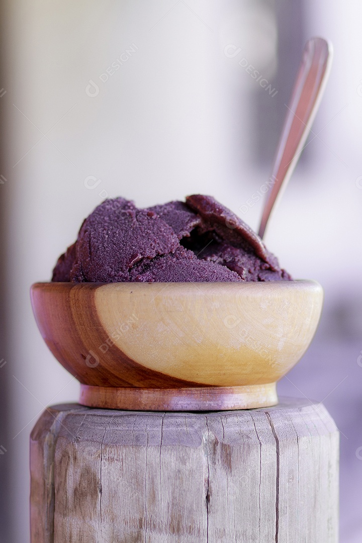 Tigela com açaí sobre tronco de madeira