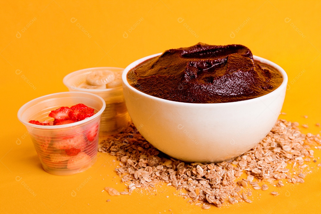 Tigela com delicioso açaí e morangos em fundo amarelo
