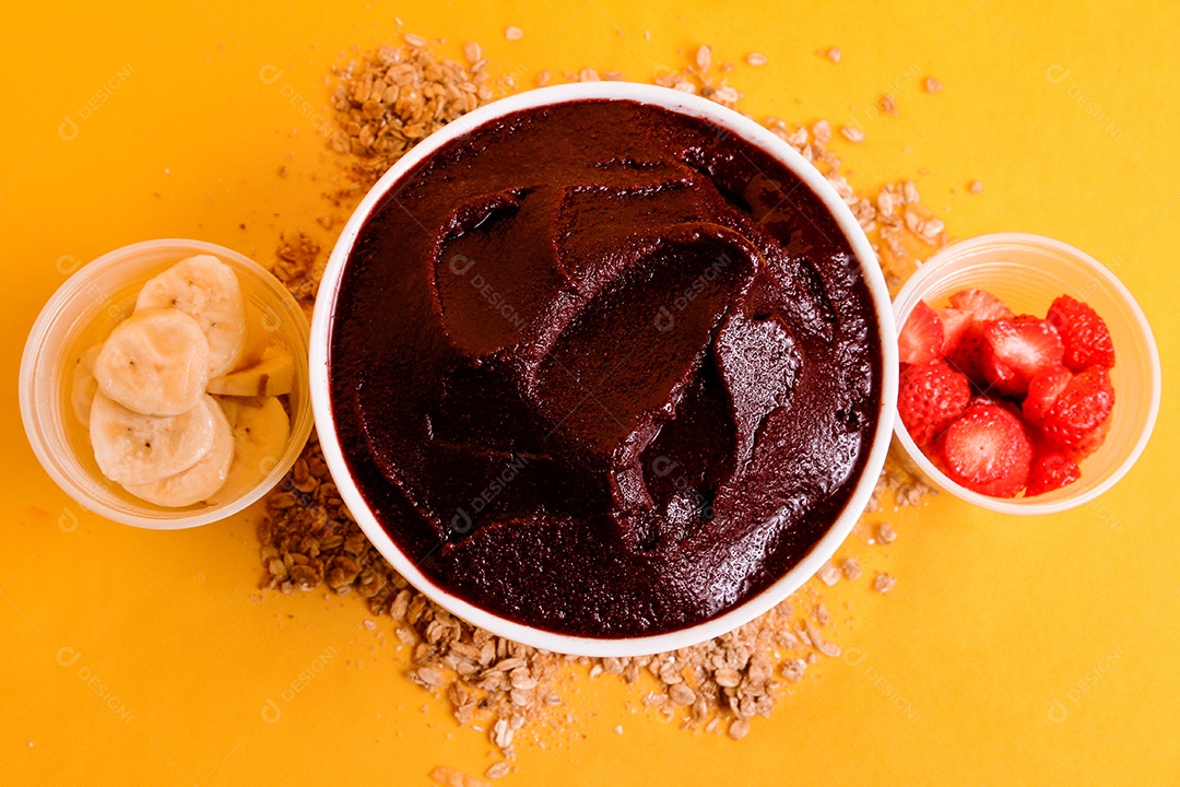 Tigela com delicioso açaí e morangos em fundo amarelo