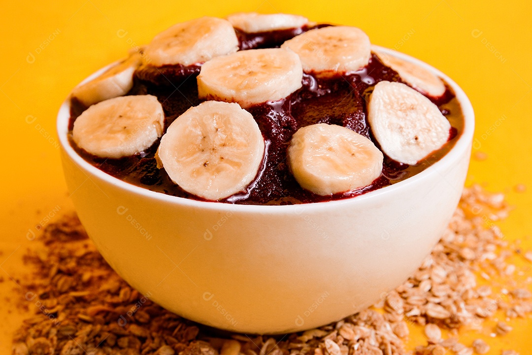 Tigela com delicioso açaí e banana em fundo amarelo