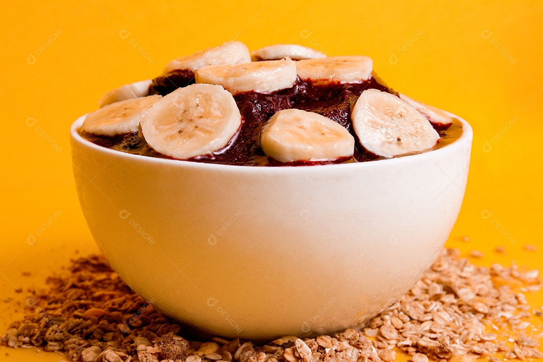 Tigela com delicioso açaí e morangos em fundo amarelo