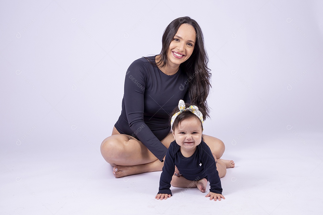 Linda mulher jovem com body preto sorridente segurando filha bebê