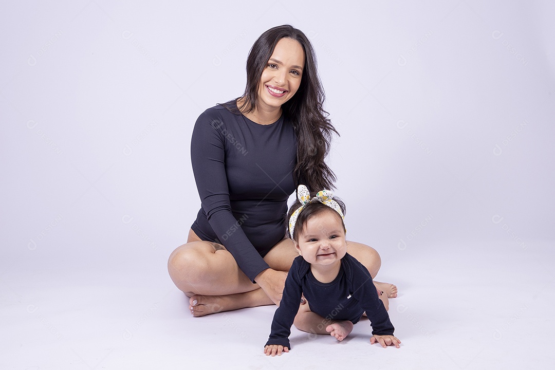 Linda mulher jovem com body preto sorridente segurando filha bebê