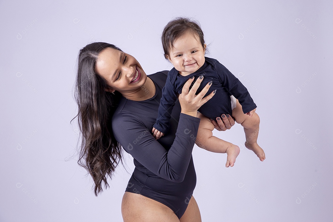 Linda mulher jovem com body preto sorridente segurando filha bebê