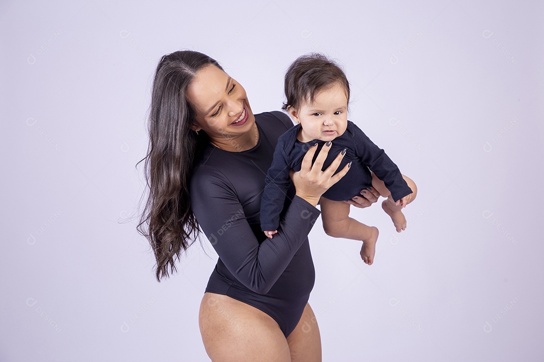 Linda mulher jovem com body preto sorridente segurando filha bebê