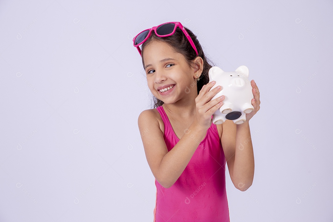 Linda garotinha sorridente com óculos de sol e maiô rosa segurando cofre