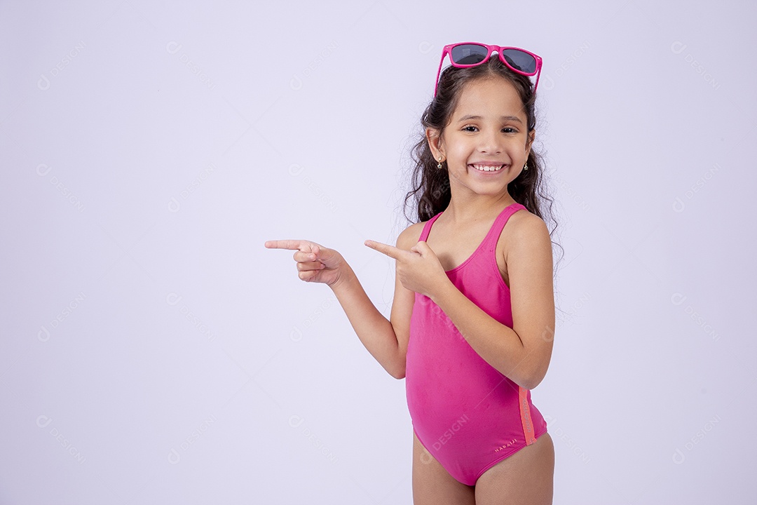 Linda garotinha sorridente com óculos de sol e maiô