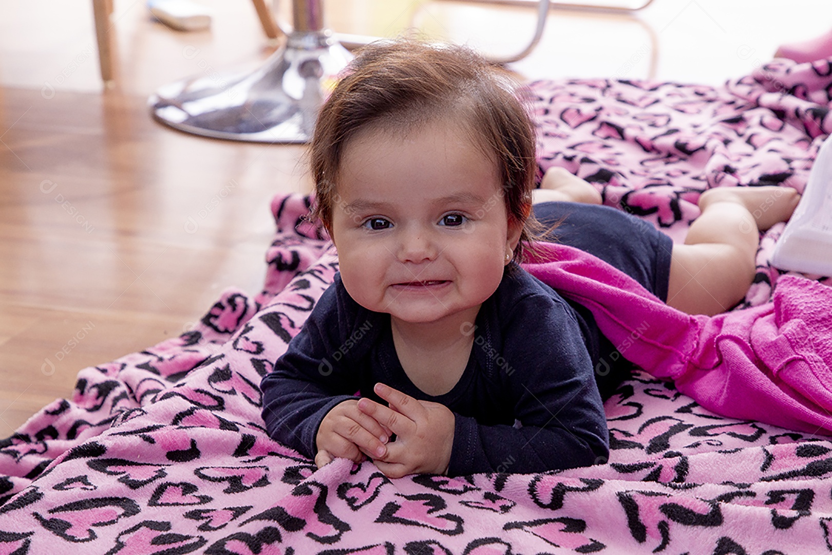 Linda bebê deitada sobre manta rosa