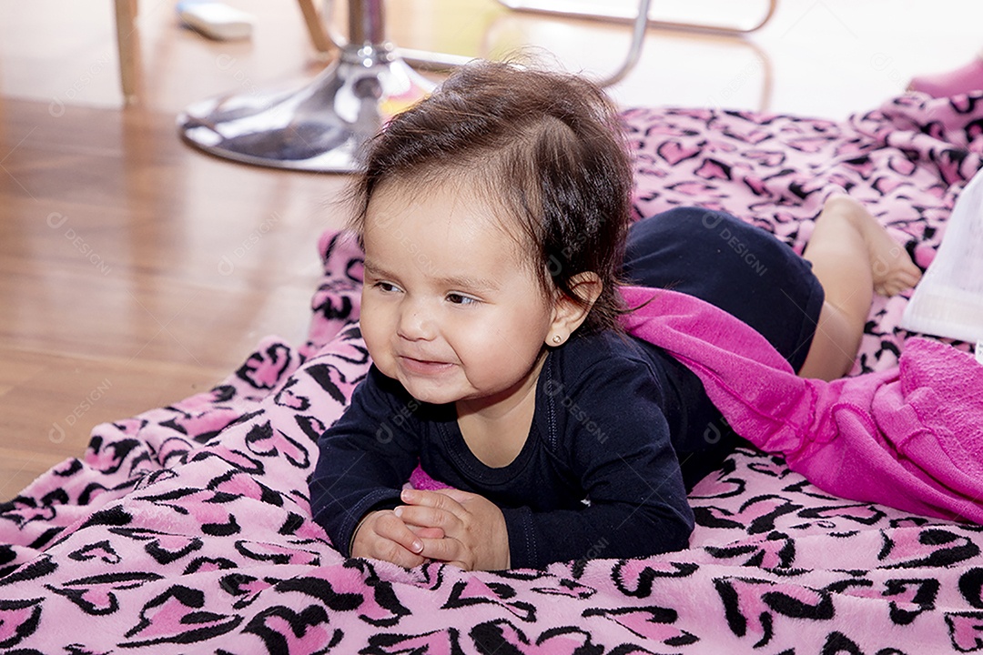 Linda bebê deitada sobre manta rosa