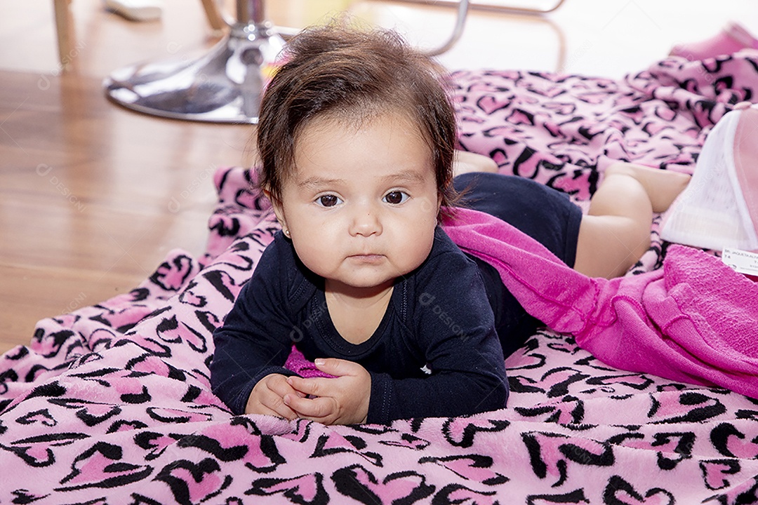 Linda bebê deitada sobre manta rosa