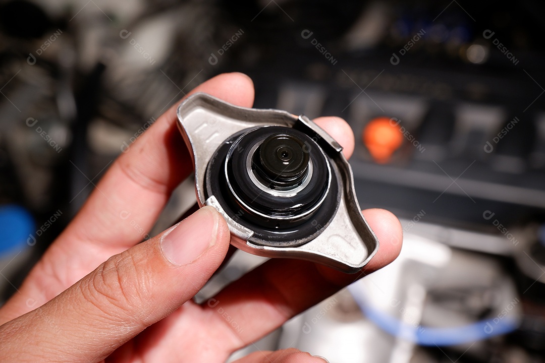 Mão mecânica segurando a tampa do radiador do carro