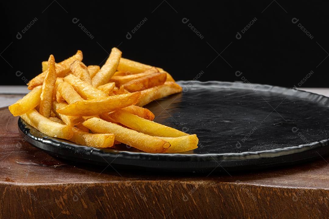 Porção de batatas fritas em um suporte na mesa de madeira rústica.