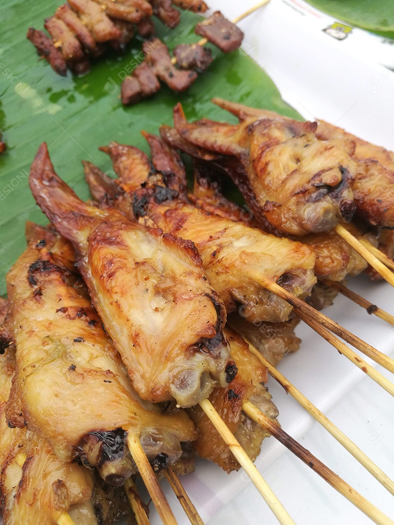 Espeto de frango sobre folha verde comida típica