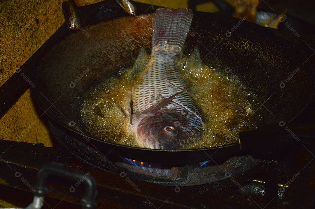 Peixe sendo frito na panela