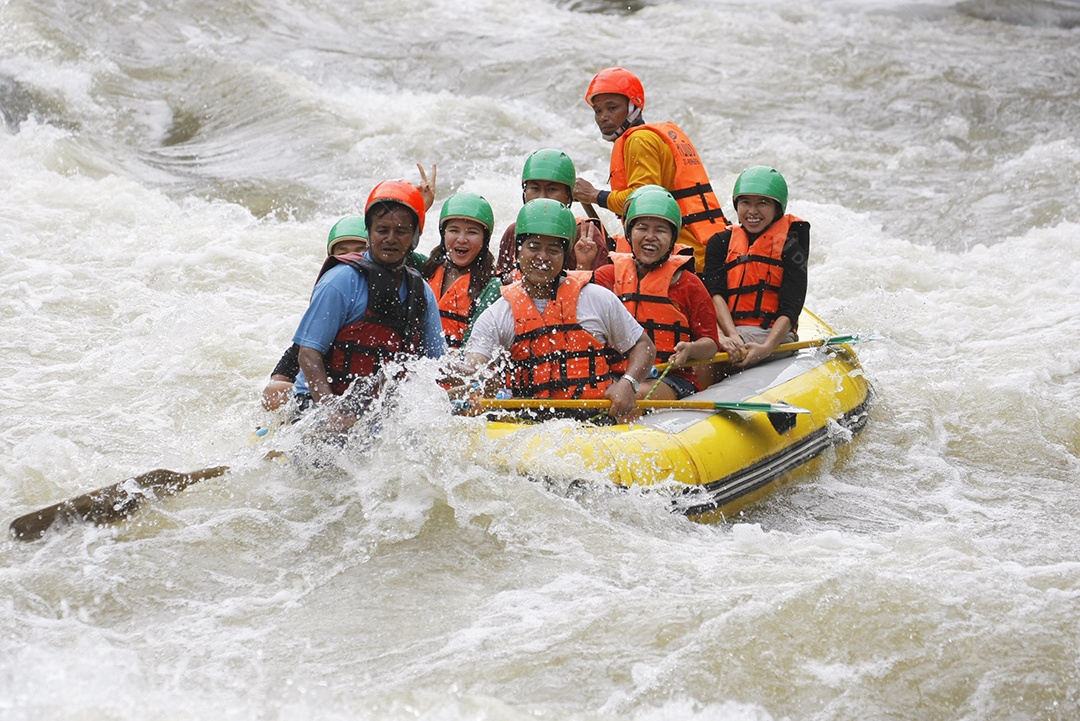 Pessoas andando com barco de boia no rio