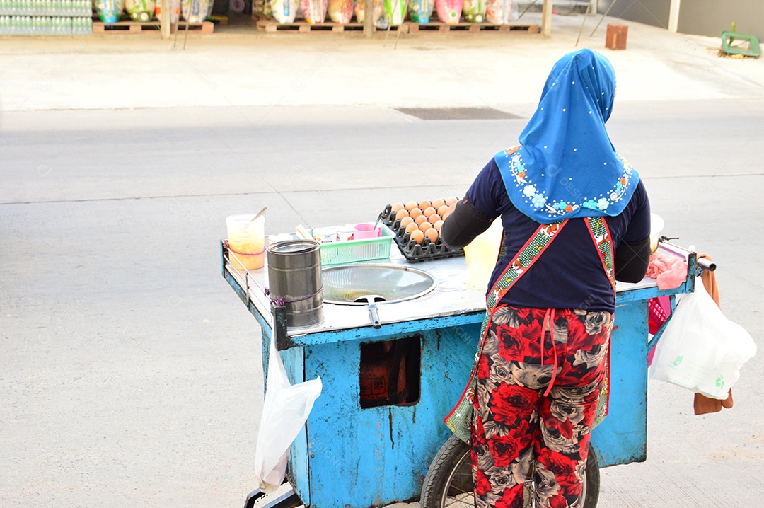 Mulher com carrinho de comida de rua